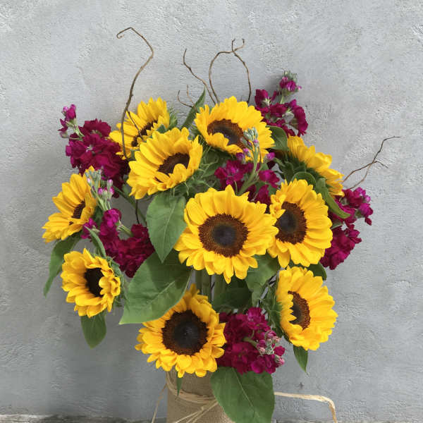 Sunflower bouquet with magenta flowers in a burlap-wrapped vase