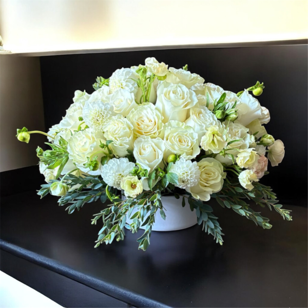 White rose and chrysanthemum arrangement in a low white vase