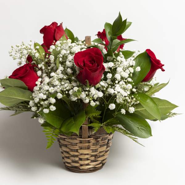 Red roses with white baby's breath in a woven basket