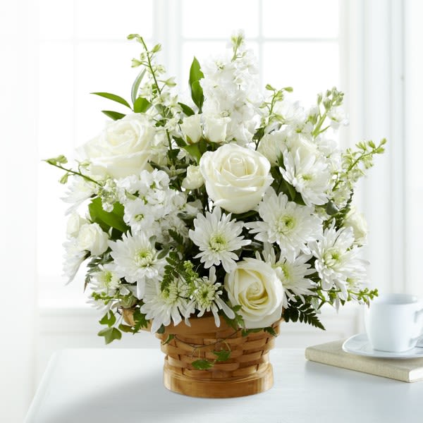 White roses and daisies arranged in a woven basket