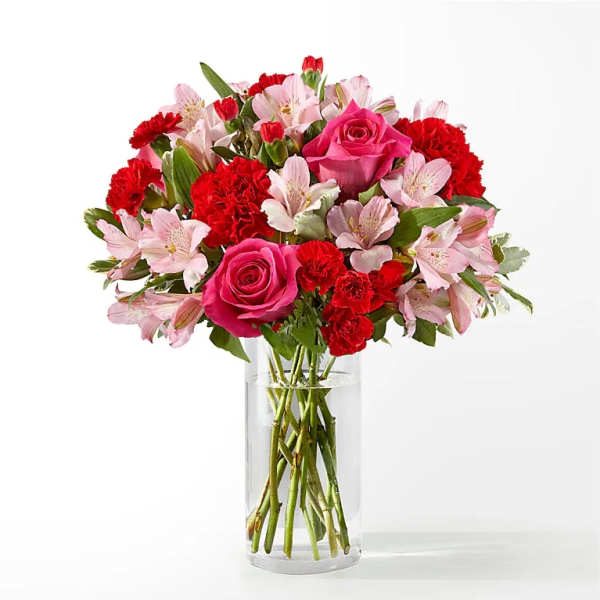 Pink roses and red carnations in a clear glass vase