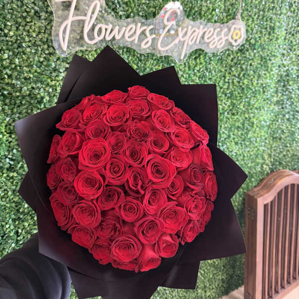 Large bouquet of red roses wrapped in black paper