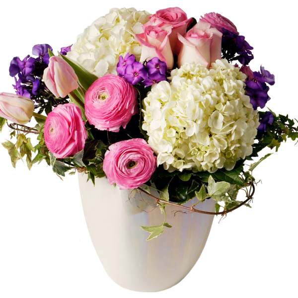 Pink roses, white hydrangeas, and purple flowers in a white vase