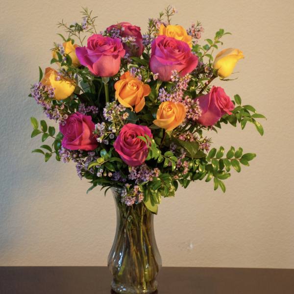 Bouquet of pink and yellow roses in a glass vase