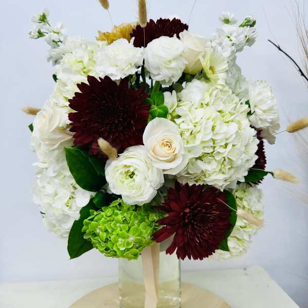 Bouquet of white and burgundy flowers in a glass vase