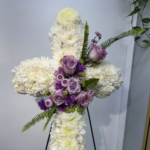 Standing floral cross with white blooms and lavender roses