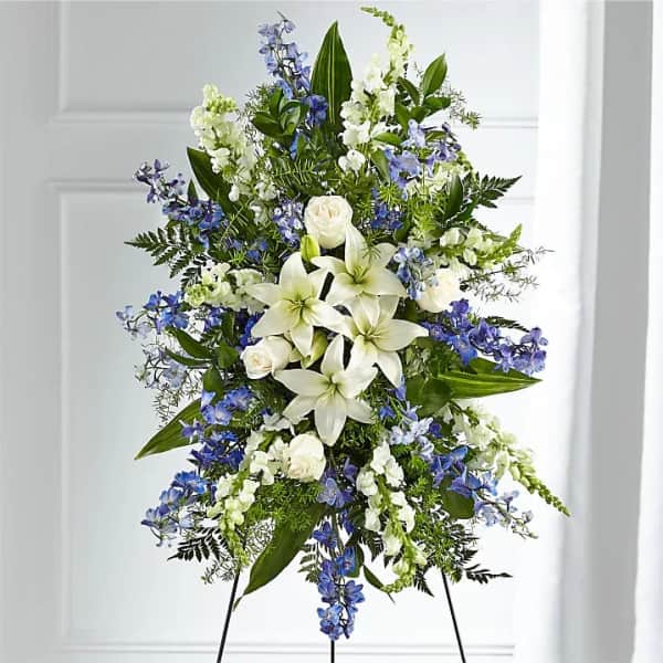 Tall white and blue floral standing spray on an easel