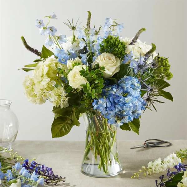 Blue and white flower arrangement in a clear glass vase