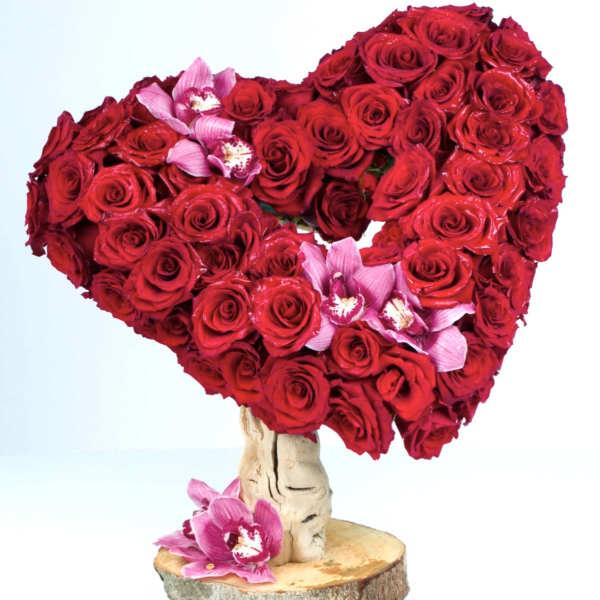Heart-shaped red rose arrangement with pink orchids on a wood base