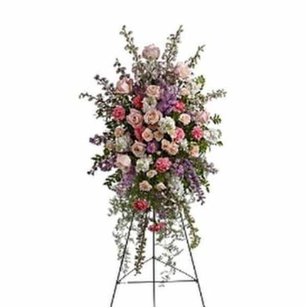 Tall standing floral spray with pink and purple blooms on a metal easel