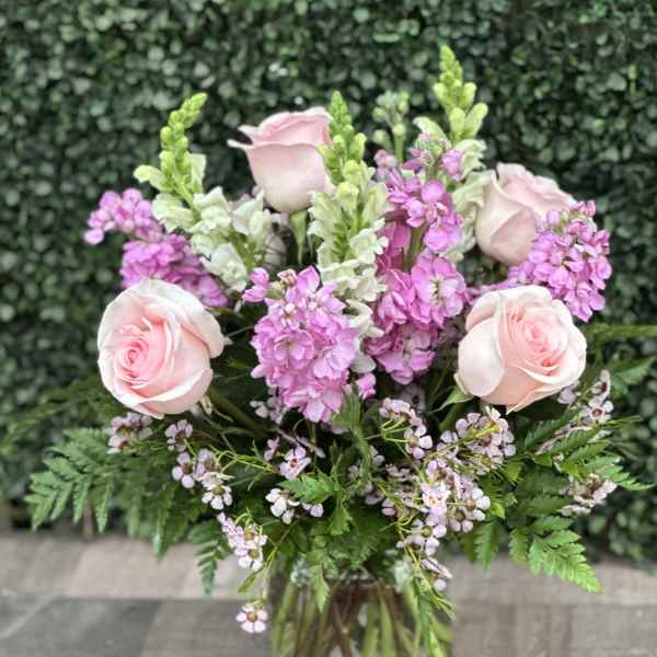 Pink roses and purple flowers in a glass vase