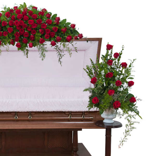 Casket with red rose sprays on top and at both sides