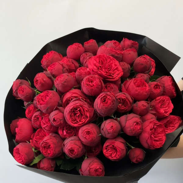 Bouquet of red roses wrapped in black paper with a red ribbon