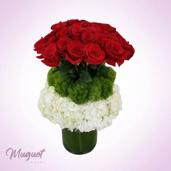Red roses and white flowers arranged in a green vase
