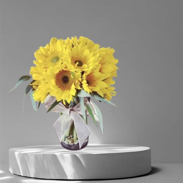 Yellow sunflower bouquet in a glass vase with a ribbon