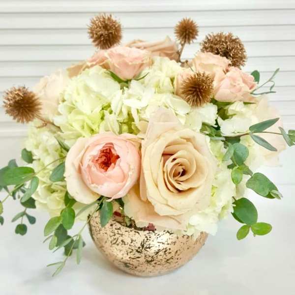 Blush roses and white hydrangeas in a speckled gold vase
