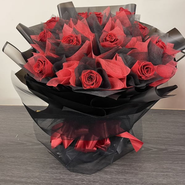 Bouquet of red roses wrapped in black and red paper