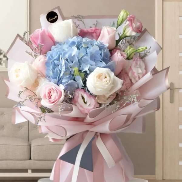 Pastel bouquet with blue hydrangea, pink and white roses, and ribbon wrap
