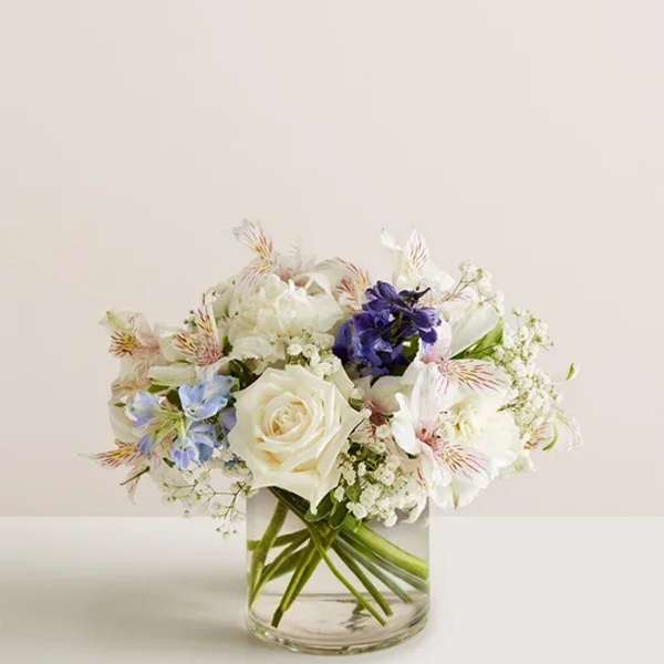 Bouquet of white and blue flowers in a clear glass vase