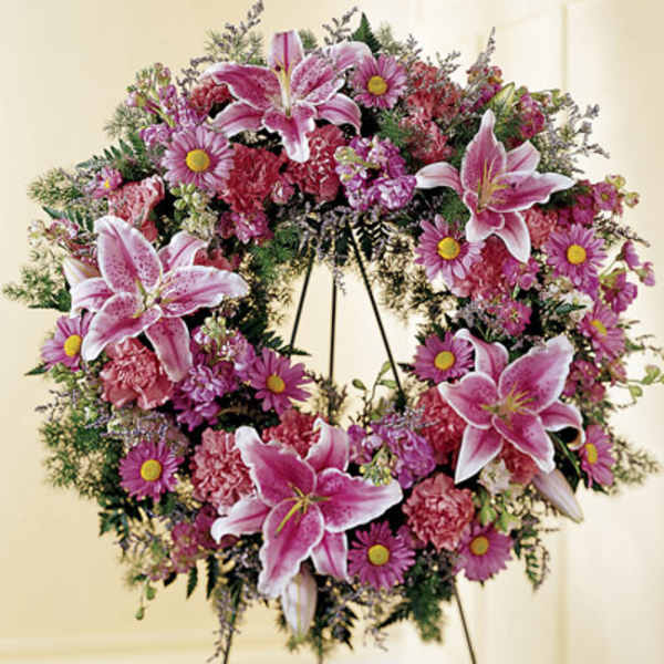 Pink lily and daisy wreath on a stand