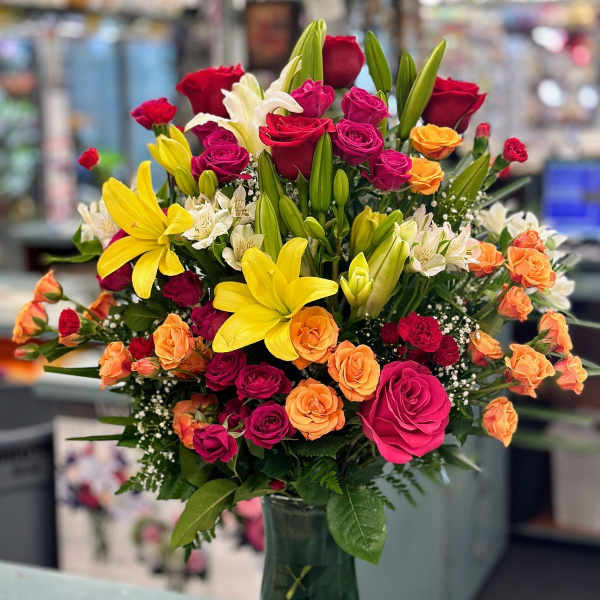 Colorful bouquet of roses and lilies in a glass vase