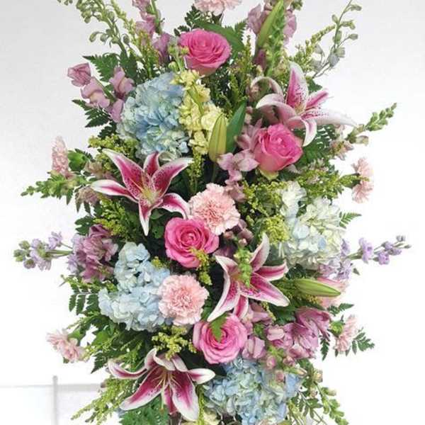 Standing spray of pink and blue flowers with lilies and roses