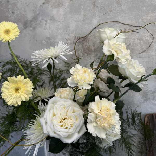 White roses and pale yellow flowers in a loose bouquet