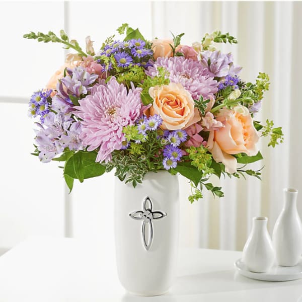 Pastel bouquet of roses, chrysanthemums, and purple daisies in a white vase