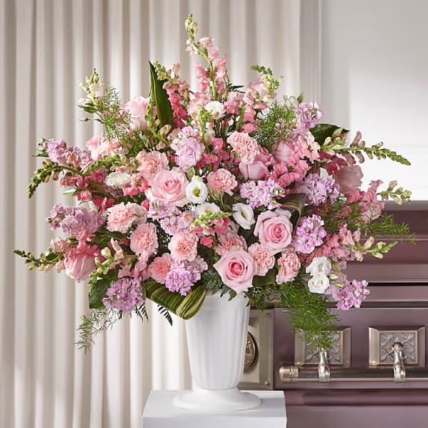 Large pink and white floral arrangement in a white vase