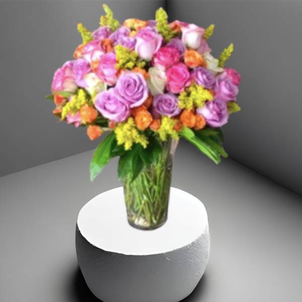 Mixed pink and purple roses in a clear glass vase