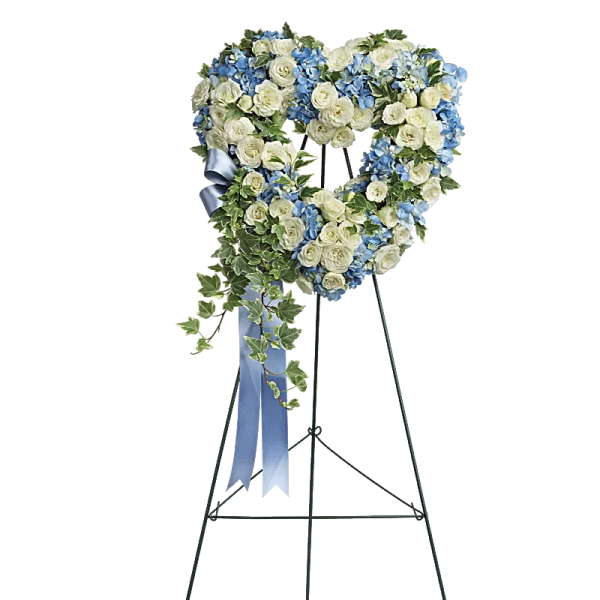 Heart-shaped floral wreath on an easel with blue and white flowers