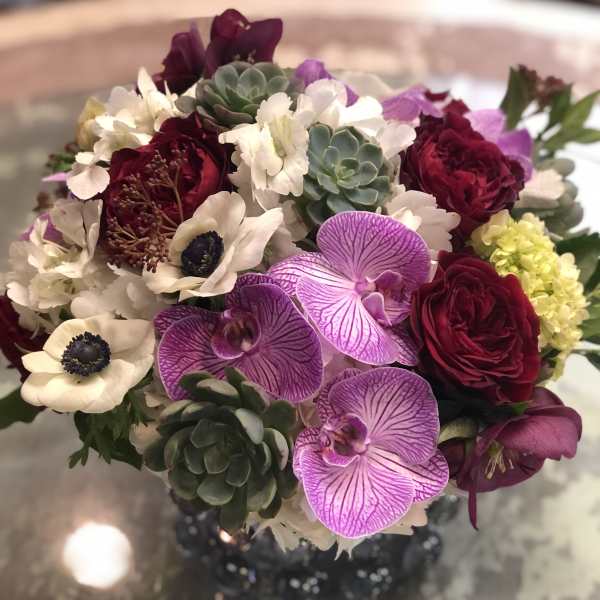 Bouquet of burgundy roses, white anemones, and purple orchids with succulents