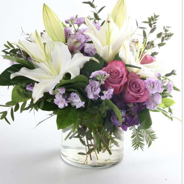 Bouquet of white lilies and pink roses in a clear glass vase