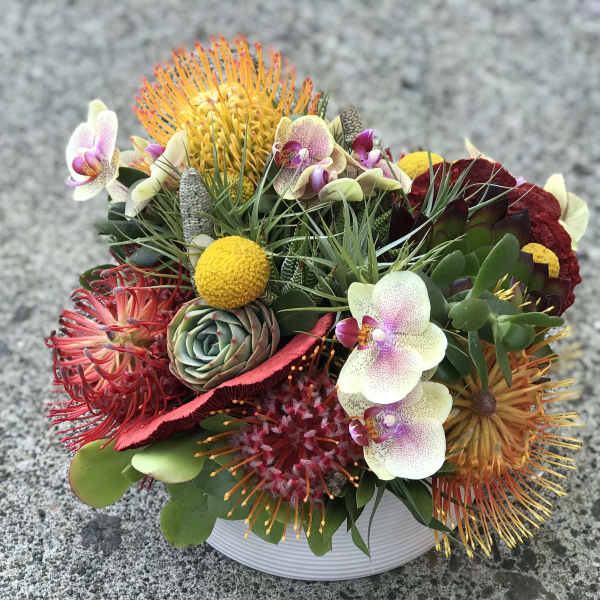Colorful mixed floral arrangement in a white bowl vase