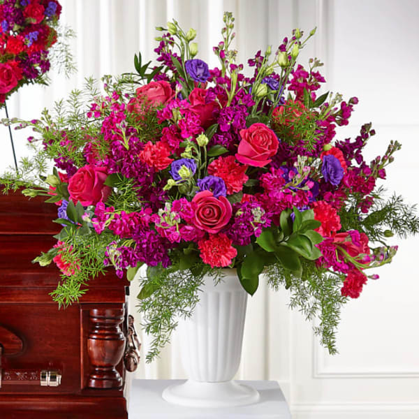 Large pink and purple floral arrangement in a white vase