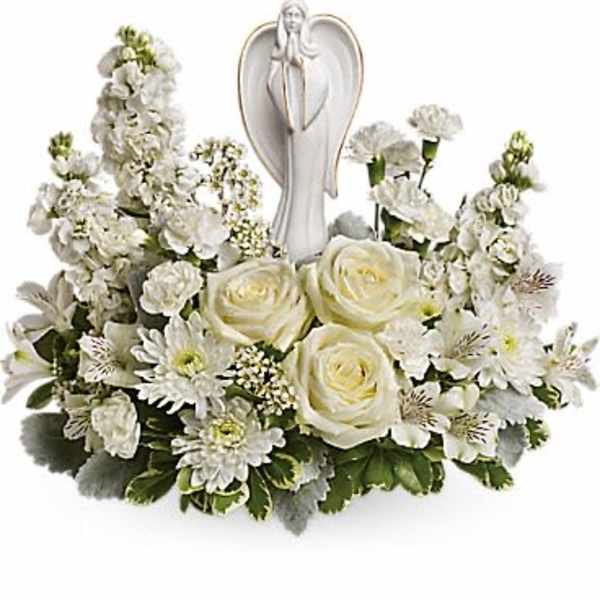White floral sympathy arrangement with an angel figurine