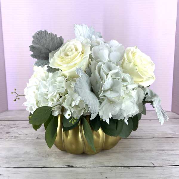 White roses and hydrangeas in a gold pumpkin vase