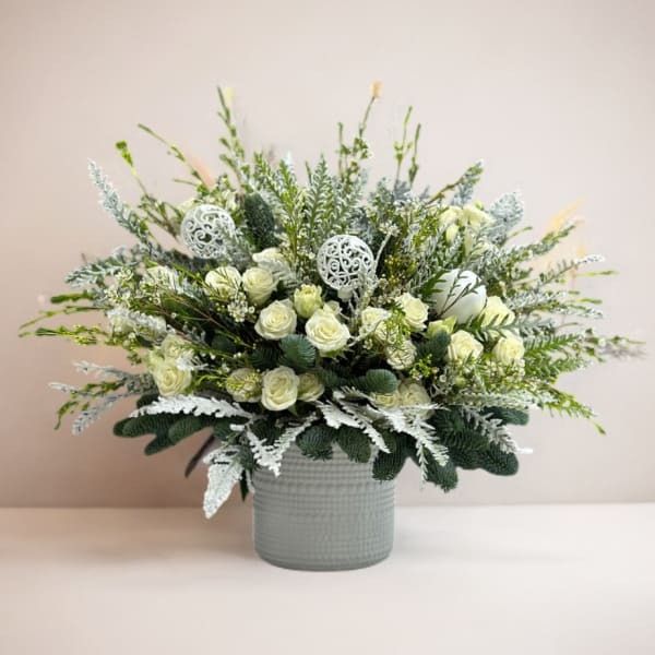 White rose arrangement in a gray vase with silver accents