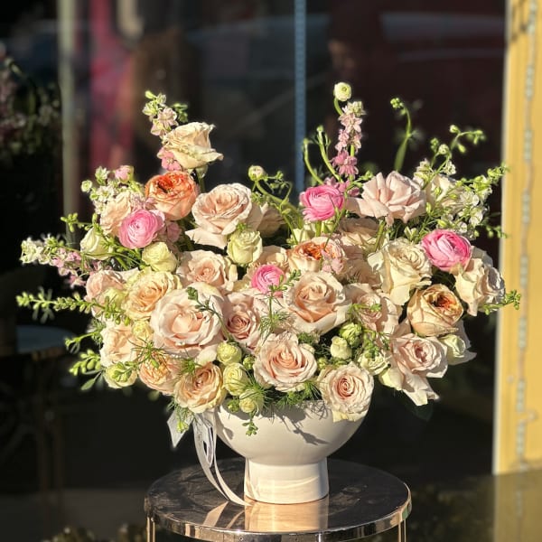 Large bouquet of blush and pink roses in a white vase