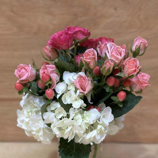 Pink roses and white hydrangeas in a clear glass vase
