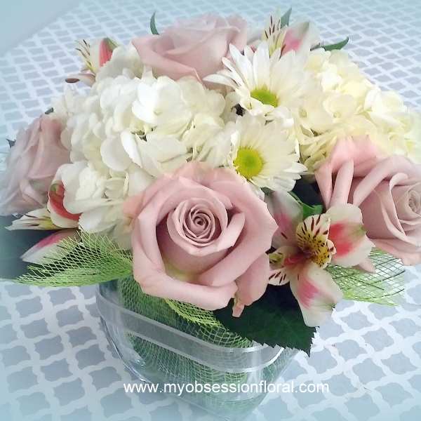 Pink roses and white daisies arranged in a clear vase