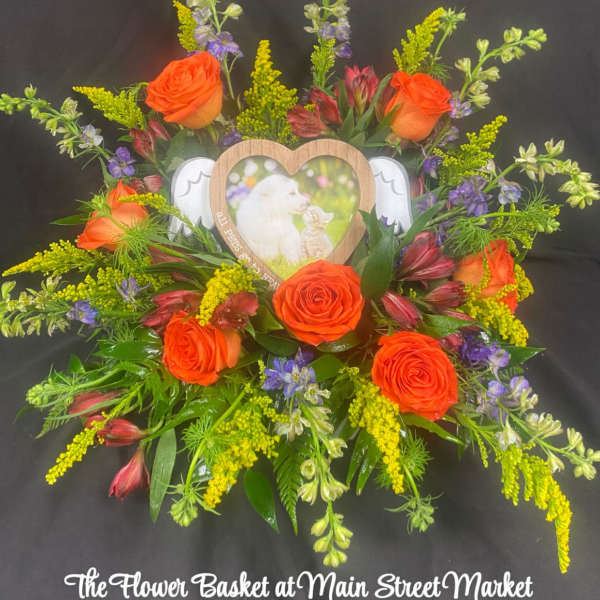 Orange roses arranged around a heart-shaped photo frame