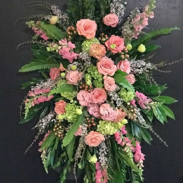 Large pink and green funeral spray with roses and lilies