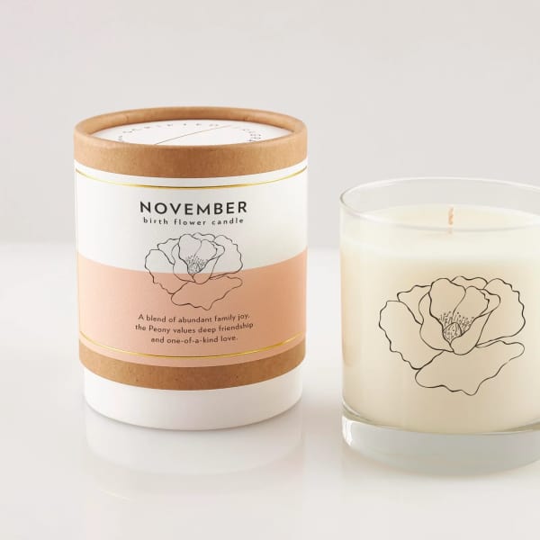 Two peony-scented candles, one in a glass jar and one in a labeled box