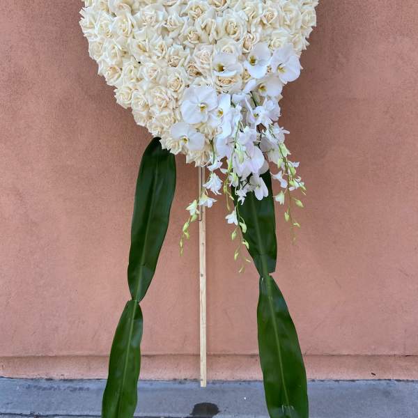Heart-shaped white rose standing spray with orchids and long green leaves