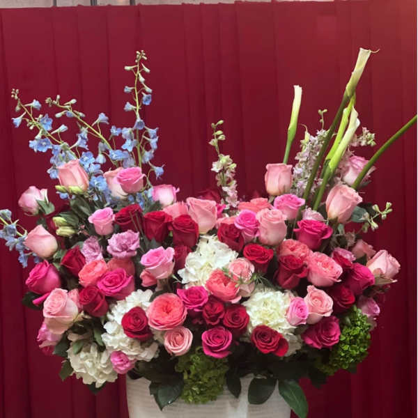 Large mixed bouquet of pink and red roses in a white vase