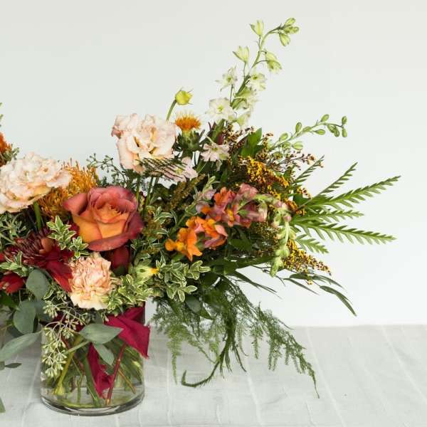 Mixed bouquet in a clear glass vase with roses and assorted blooms
