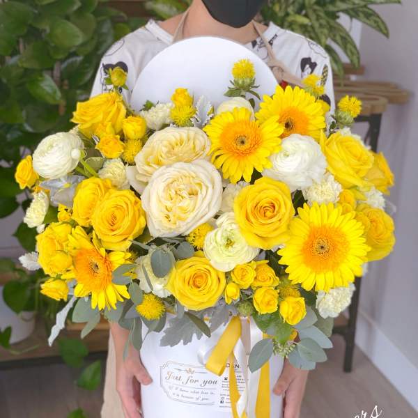 Yellow and white bouquet of roses and daisies in a white box