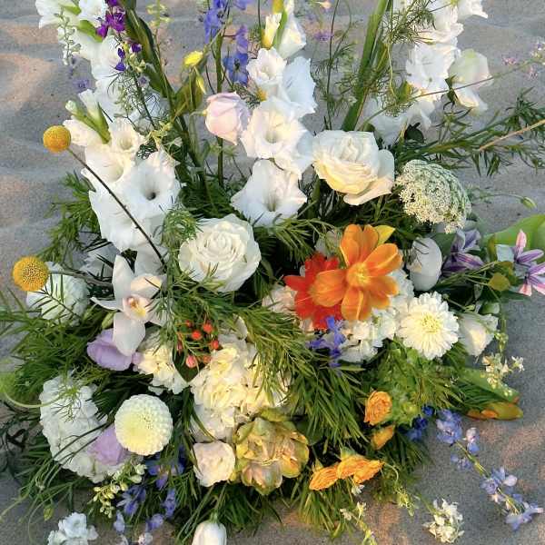 Large mixed floral arrangement with white, purple, and orange blooms