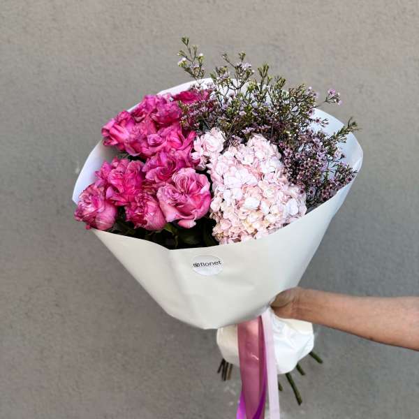 Pink rose and hydrangea bouquet wrapped in white paper